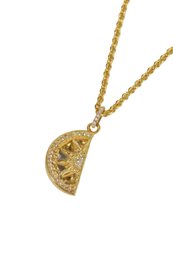 Gold necklace with a lemon-slice pendant on a white background