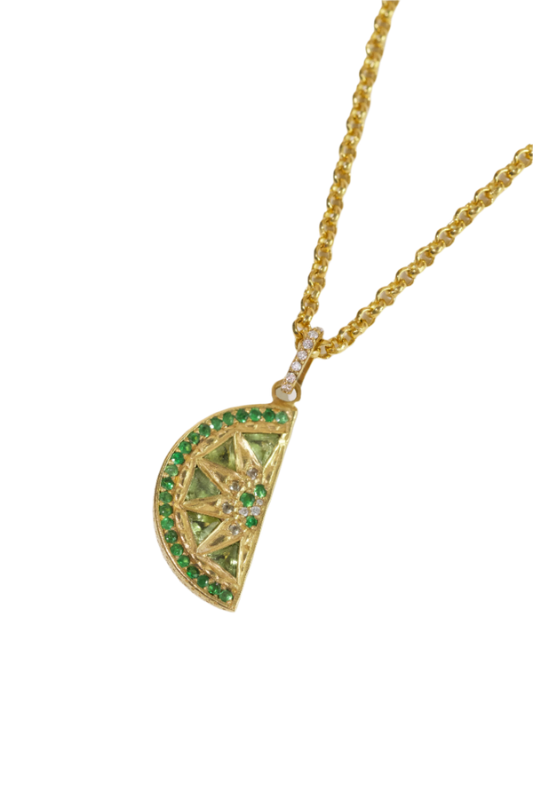 Gold necklace with a lime-slice pendant on a white background